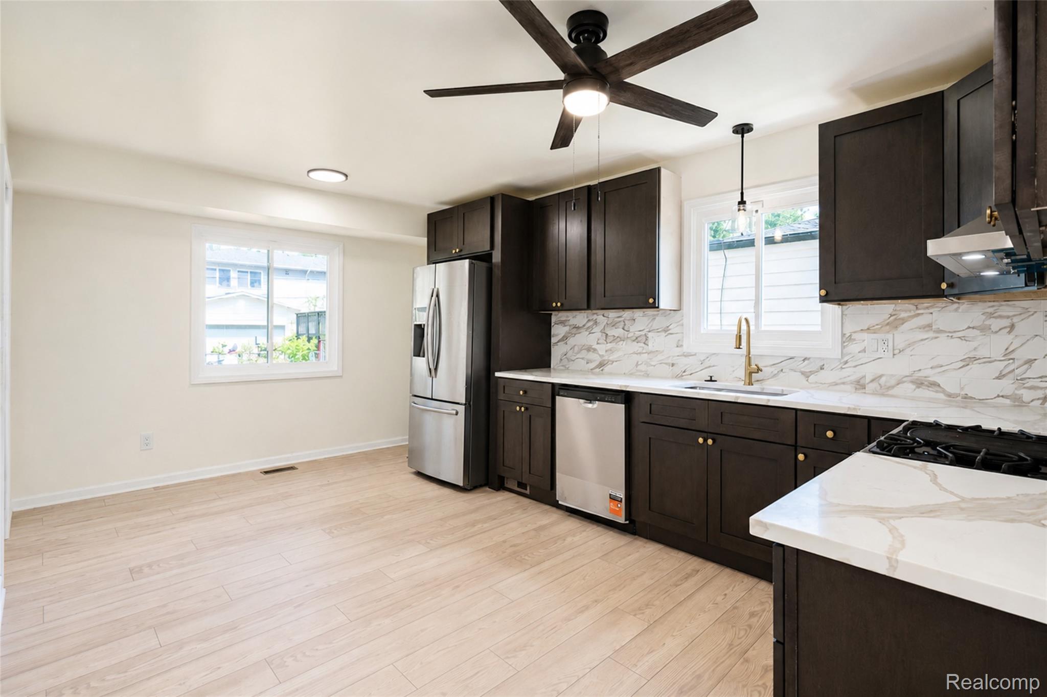 201 Cardwell Street Inkster, MI 48141 - Photo 10 of 41 Kitchen featuring wood-finish flooring, dark wood cabinetry, and stainless steel appliances