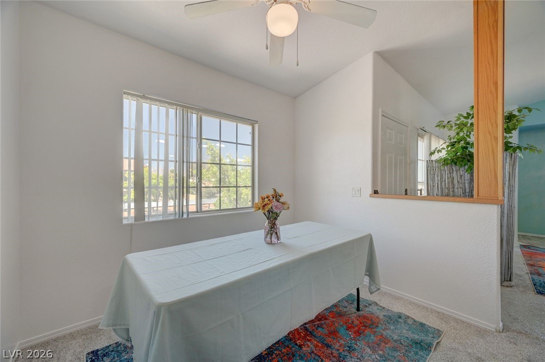3318 North Decatur Boulevard, Unit 2072 Las Vegas, NV 89130 - Photo 15 of 50 A well-lit dining area featuring a window, ceiling fan, and carpeted flooring.