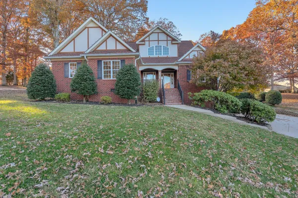 a front view of a house with a yard and trees