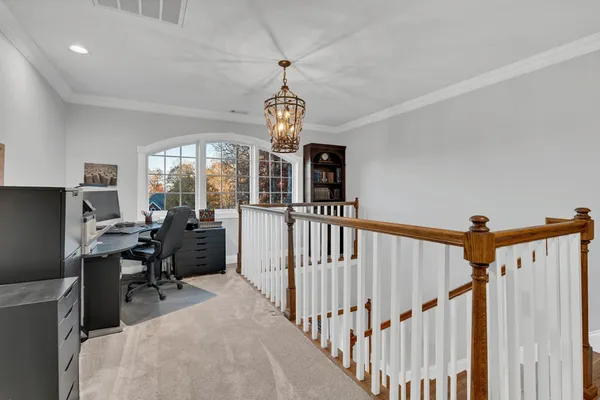 a bedroom with a bed chandelier and a window