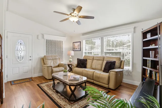 a living room with furniture a bookshelf and a large window