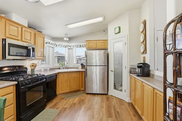 a kitchen with stainless steel appliances granite countertop a refrigerator stove and sink