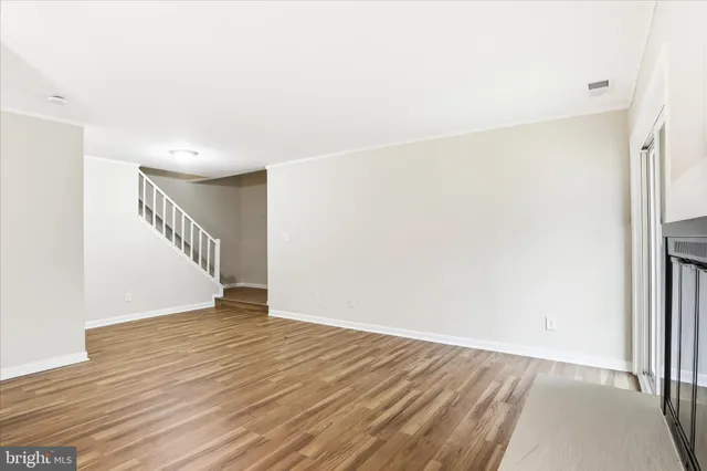 an empty room with wooden floor and fireplace