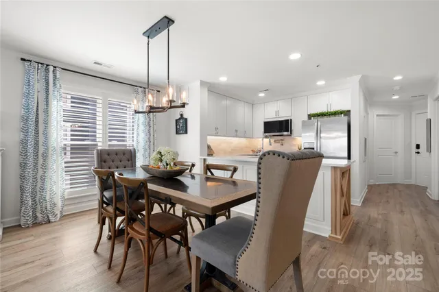a dining room with furniture a rug and a chandelier