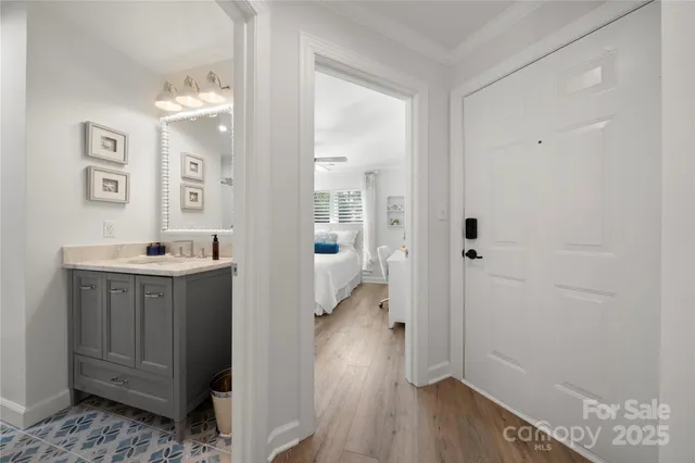 a bedroom with a bed next to a large window with wooden floor