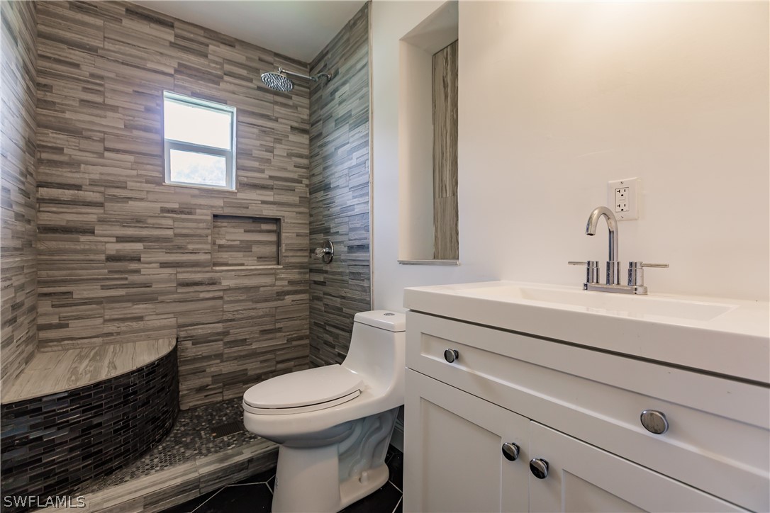 2502 Lake Trafford Road Immokalee, FL 34142 - Photo 8 of 15 a bathroom with a sink a toilet and mirror