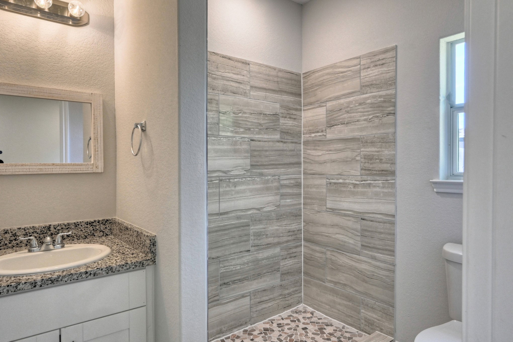 9810 Arbor Oak Willis, TX 77318 - Photo 22 of 43 a bathroom with a granite countertop sink a toilet and shower