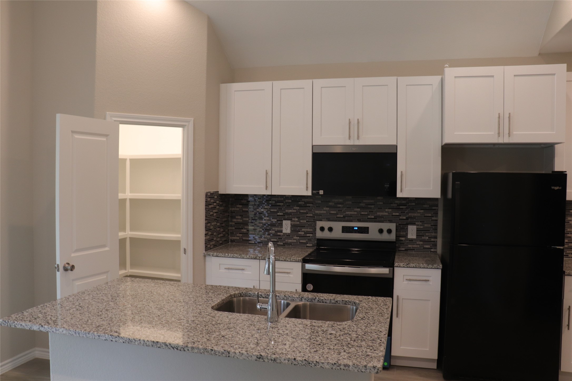 9810 Arbor Oak Willis, TX 77318 - Photo 3 of 43 a kitchen with granite countertop a stove and a refrigerator
