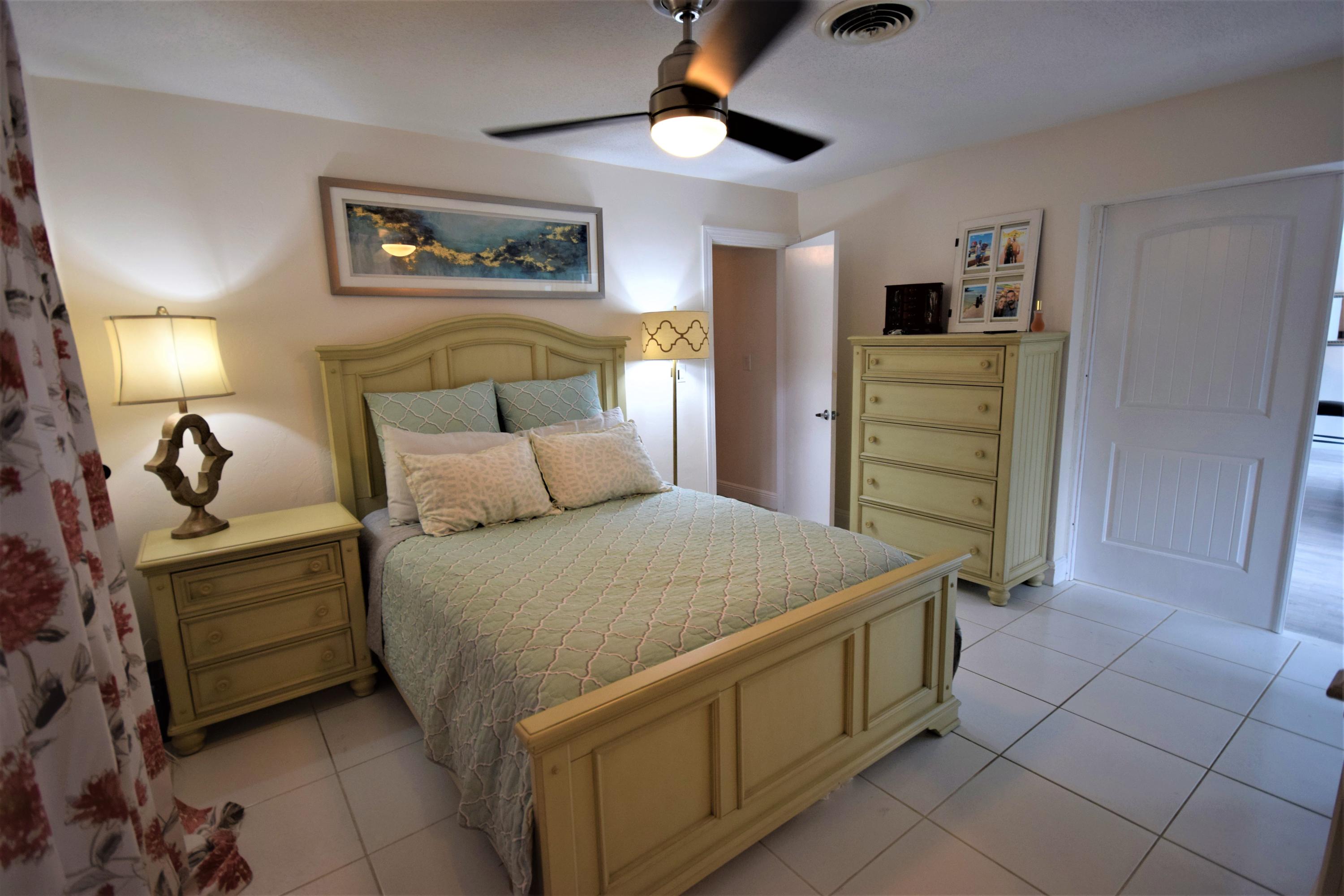 2770 Northeast 25th Terrace Boca Raton, FL 33431 - Photo 18 of 34 a bed room with a bed and a ceiling fan