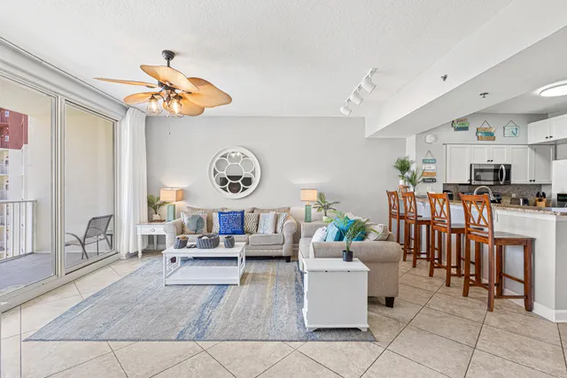 a living room with lots of furniture and view of kitchen