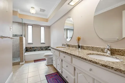 a bathroom with a granite countertop double vanity sink and a mirror