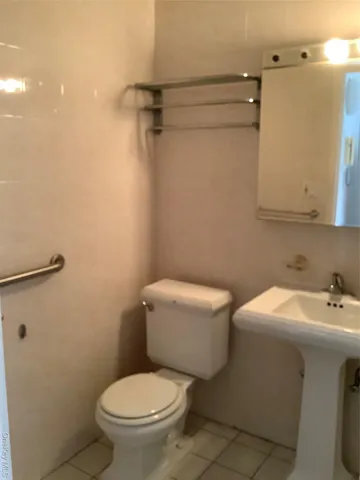 a white toilet sitting next to a bathroom sink