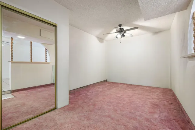 an empty room and chandelier fan