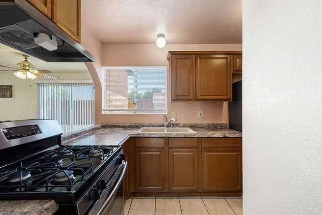 a kitchen with granite countertop a stove and a sink