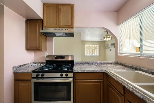 a kitchen with granite countertop a stove sink and cabinets