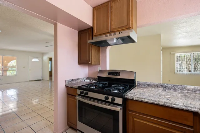 a kitchen with granite countertop stainless steel appliances a stove a sink and dishwasher