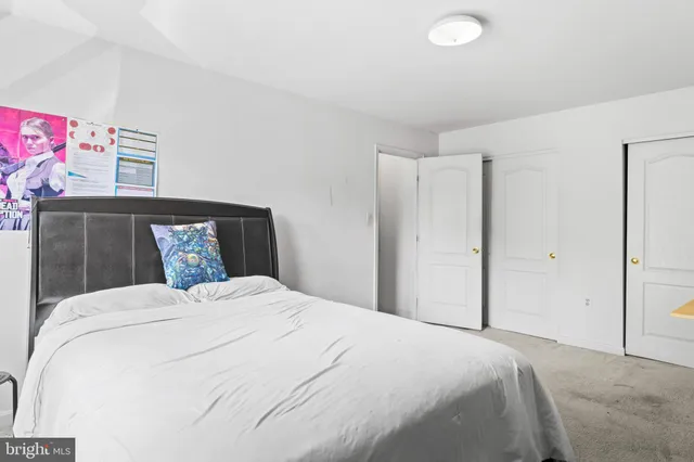 a bedroom with a bed and a painting on the wall