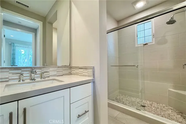 a bathroom with a granite countertop sink mirror and shower