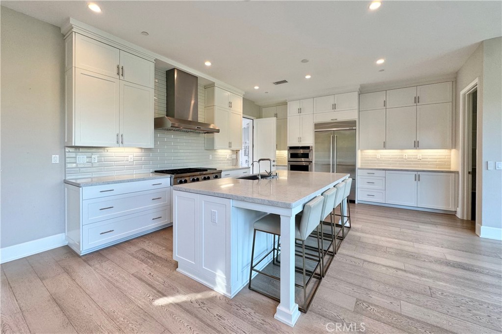 115 Locanda Irvine, CA 92602 - Photo 6 of 28 a kitchen with kitchen island a stove a sink and a refrigerator