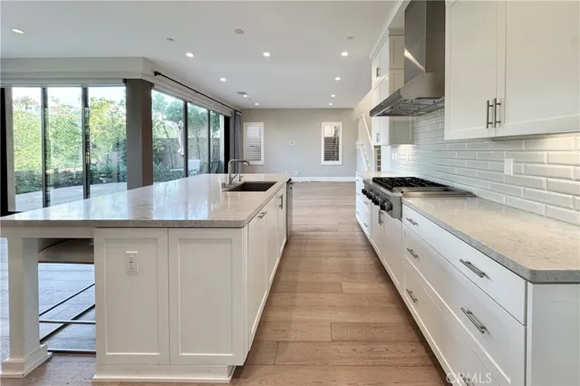 a large kitchen with stainless steel appliances granite countertop a sink and cabinets