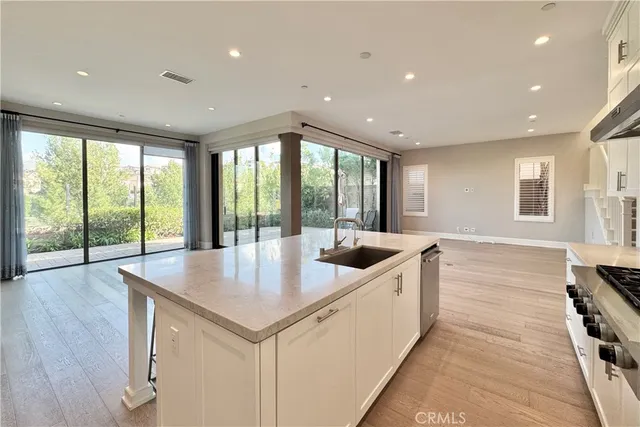 a open kitchen with stainless steel appliances granite countertop a sink and a large window