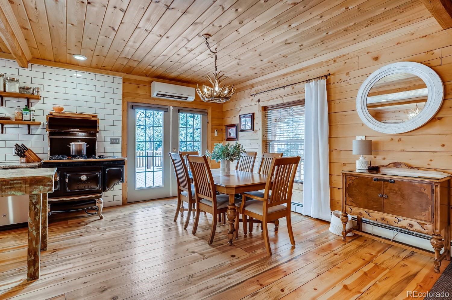13380 South Foxton Road Conifer, CO 80433 - Photo 11 of 40 a dining room with furniture a chandelier and wooden floor