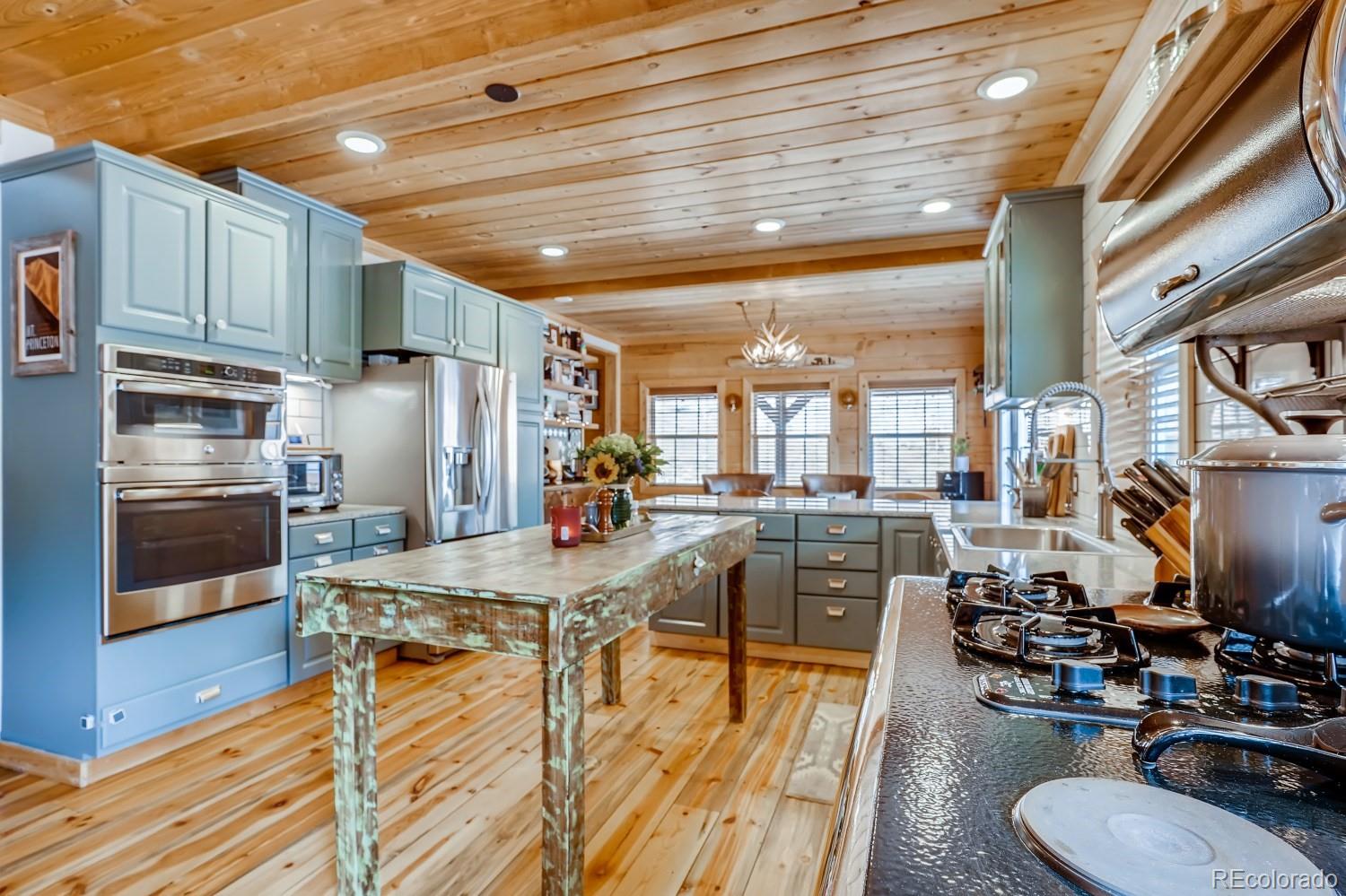 13380 South Foxton Road Conifer, CO 80433 - Photo 13 of 40 a room with stainless steel appliances kitchen island granite countertop wooden floor a dining table and chairs