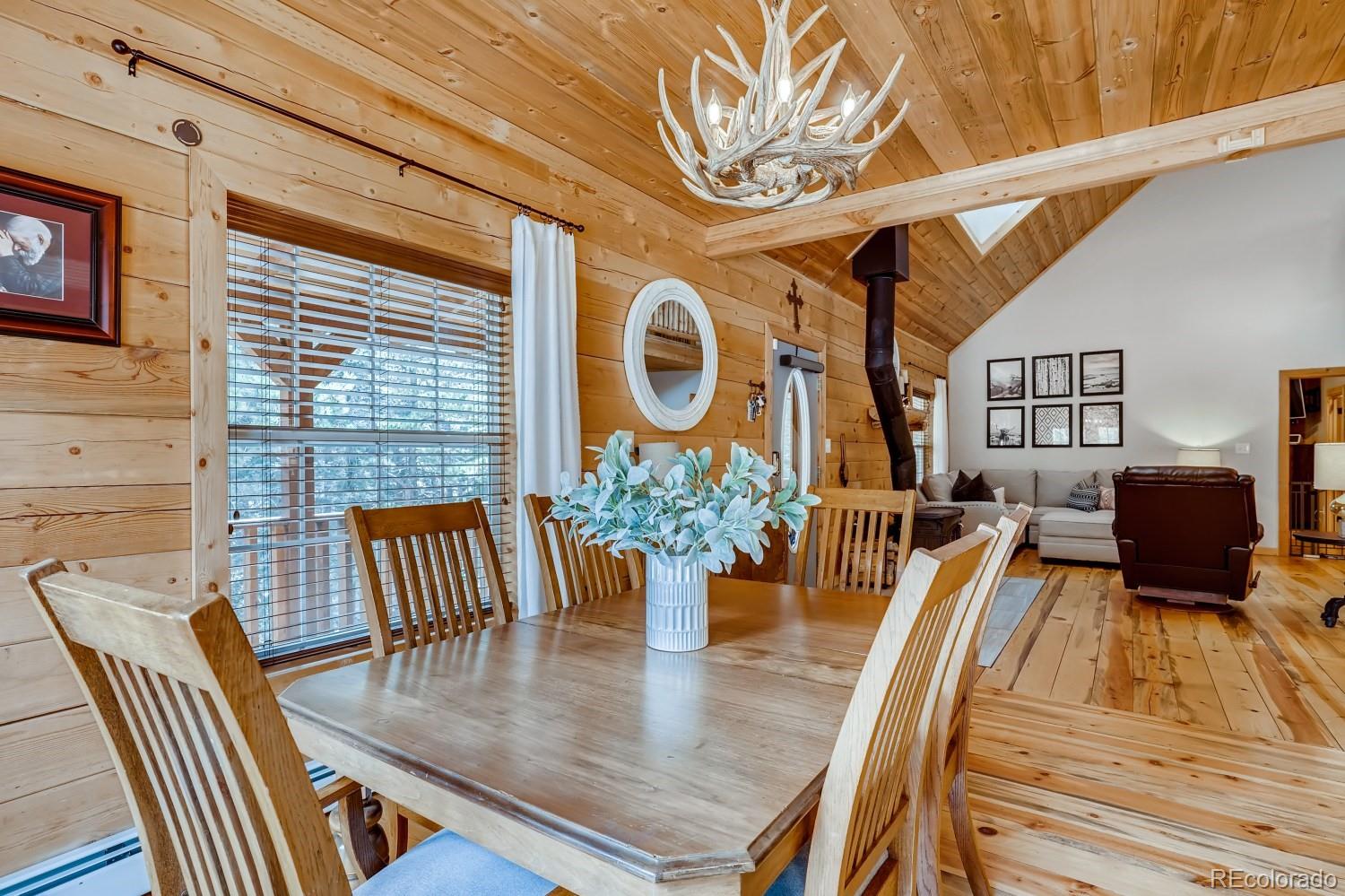 13380 South Foxton Road Conifer, CO 80433 - Photo 14 of 40 a view of a dining room with furniture a chandelier and wooden floor