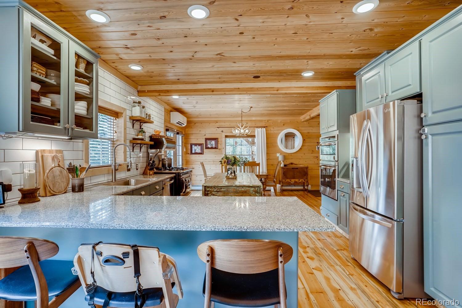 13380 South Foxton Road Conifer, CO 80433 - Photo 15 of 40 a kitchen with stainless steel appliances granite countertop a table chairs and a refrigerator