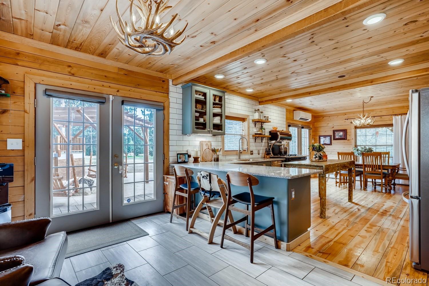 13380 South Foxton Road Conifer, CO 80433 - Photo 16 of 40 a dining hall with stainless steel appliances granite countertop a stove a sink a dining table and chairs with wooden floor