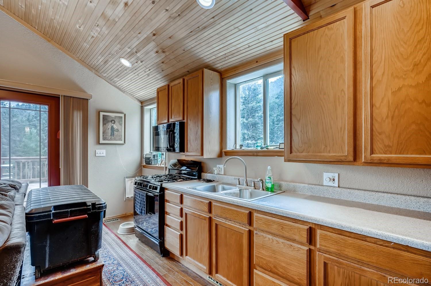 13380 South Foxton Road Conifer, CO 80433 - Photo 34 of 40 a kitchen with stainless steel appliances a stove sink and cabinets