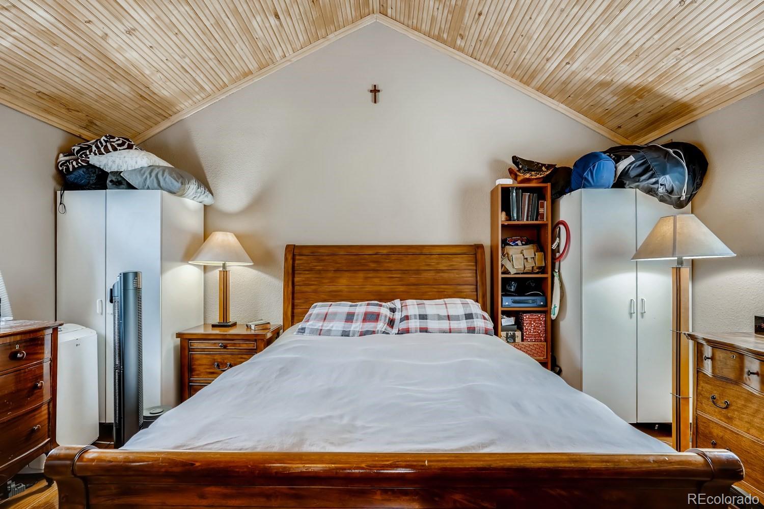 13380 South Foxton Road Conifer, CO 80433 - Photo 35 of 40 a bedroom with a bed and a lamp