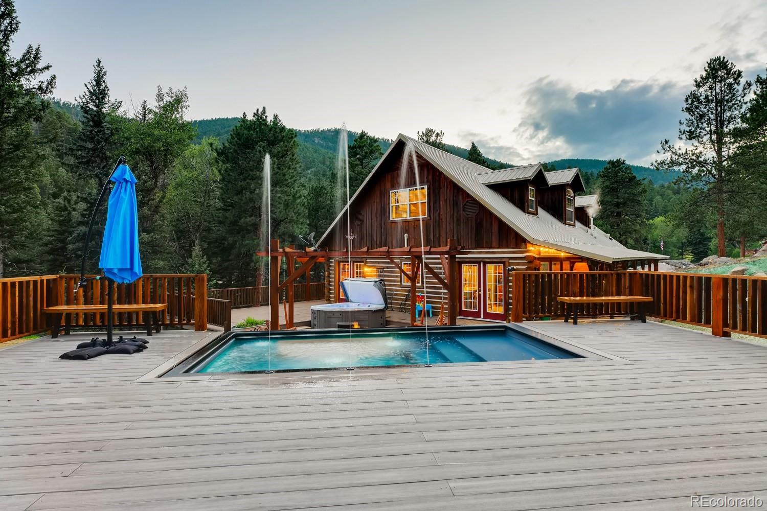 13380 South Foxton Road Conifer, CO 80433 - Photo 4 of 40 a view of a house with wooden deck and furniture