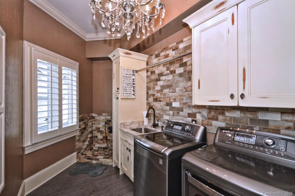 18301 Bowsprit Pointe Road Cornelius, NC 28031 - Photo 18 of 24 a utility room with stainless steel appliances a stove a chimney a sink and cabinets