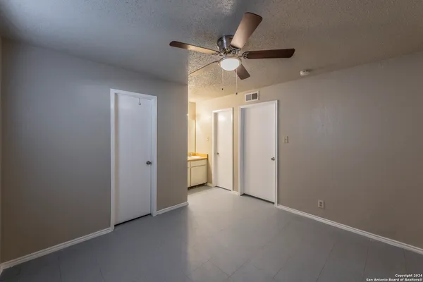 an empty room with a ceiling fan and a window