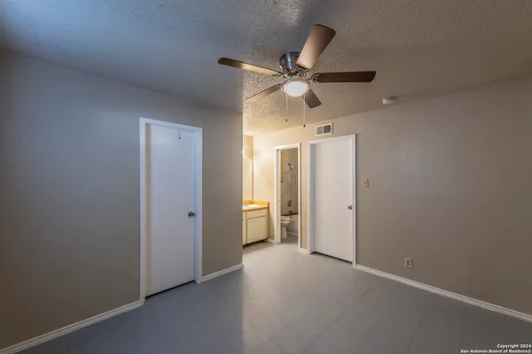 an empty room and chandelier fan