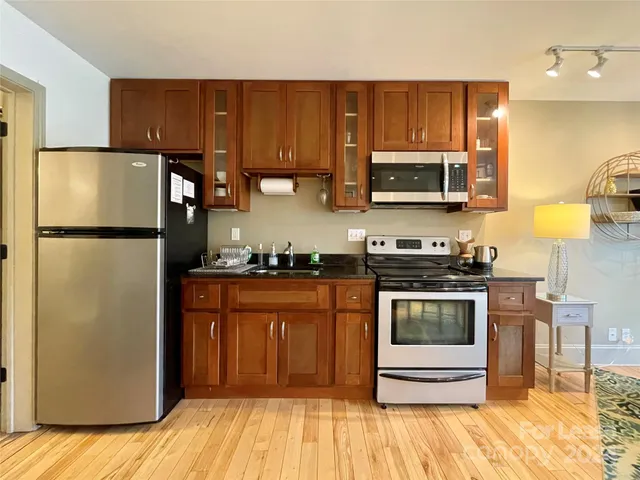 a kitchen with stainless steel appliances granite countertop a refrigerator stove top oven and sink