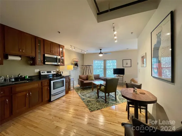 a kitchen with stainless steel appliances granite countertop a stove refrigerator and a coffee table