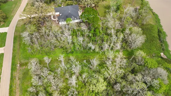 an aerial view of residential houses with outdoor space and trees