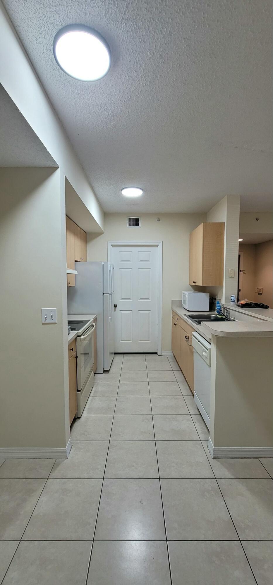 5032 Lantana Road, Unit 2105 Lake Worth, FL 33463 - Photo 3 of 15 a kitchen with a stove top oven and cabinets