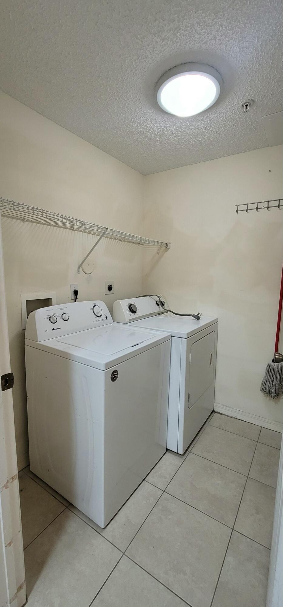 5032 Lantana Road, Unit 2105 Lake Worth, FL 33463 - Photo 4 of 15 a utility room with a washer dryer and white cabinets