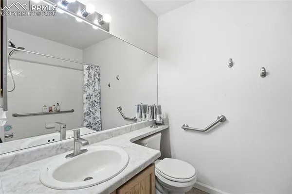 a bathroom with a sink a toilet and shower