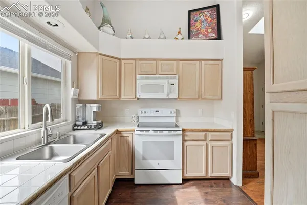 a kitchen with white cabinets sink and stove