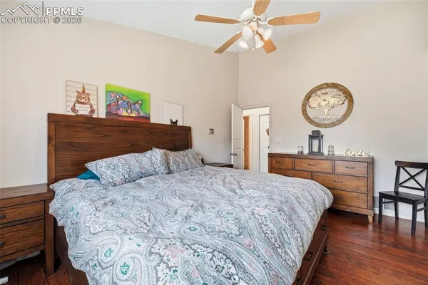 a bedroom with a bed a clock on the wall and dresser