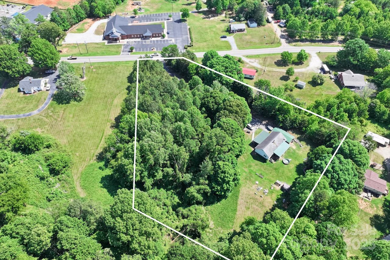 an aerial view of residential houses with outdoor space and trees