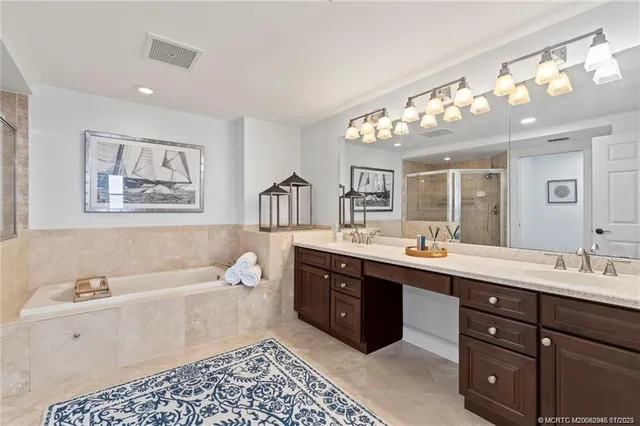 a spacious bathroom with a double vanity sink mirror and bathtub