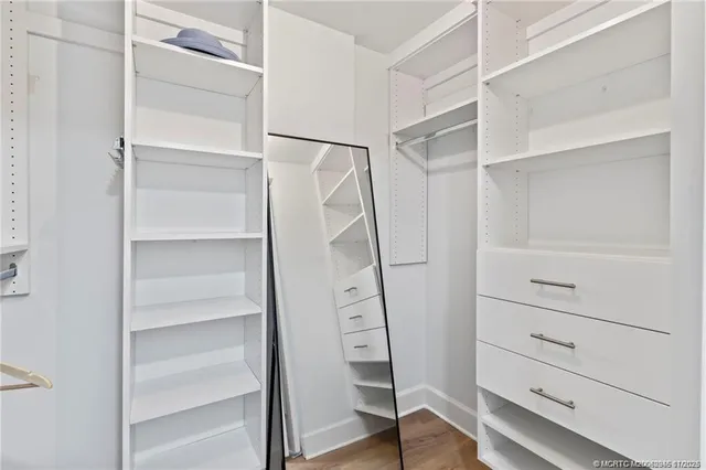 a view of walk in closet with empty racks