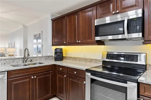 a kitchen with granite countertop a stove and a microwave