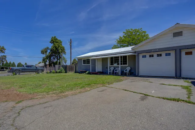 a front view of a house with a yard and potted plants