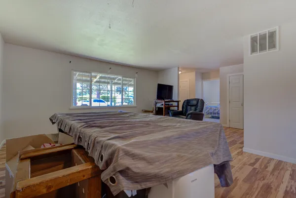 a bed sitting in a spacious bedroom next to a window